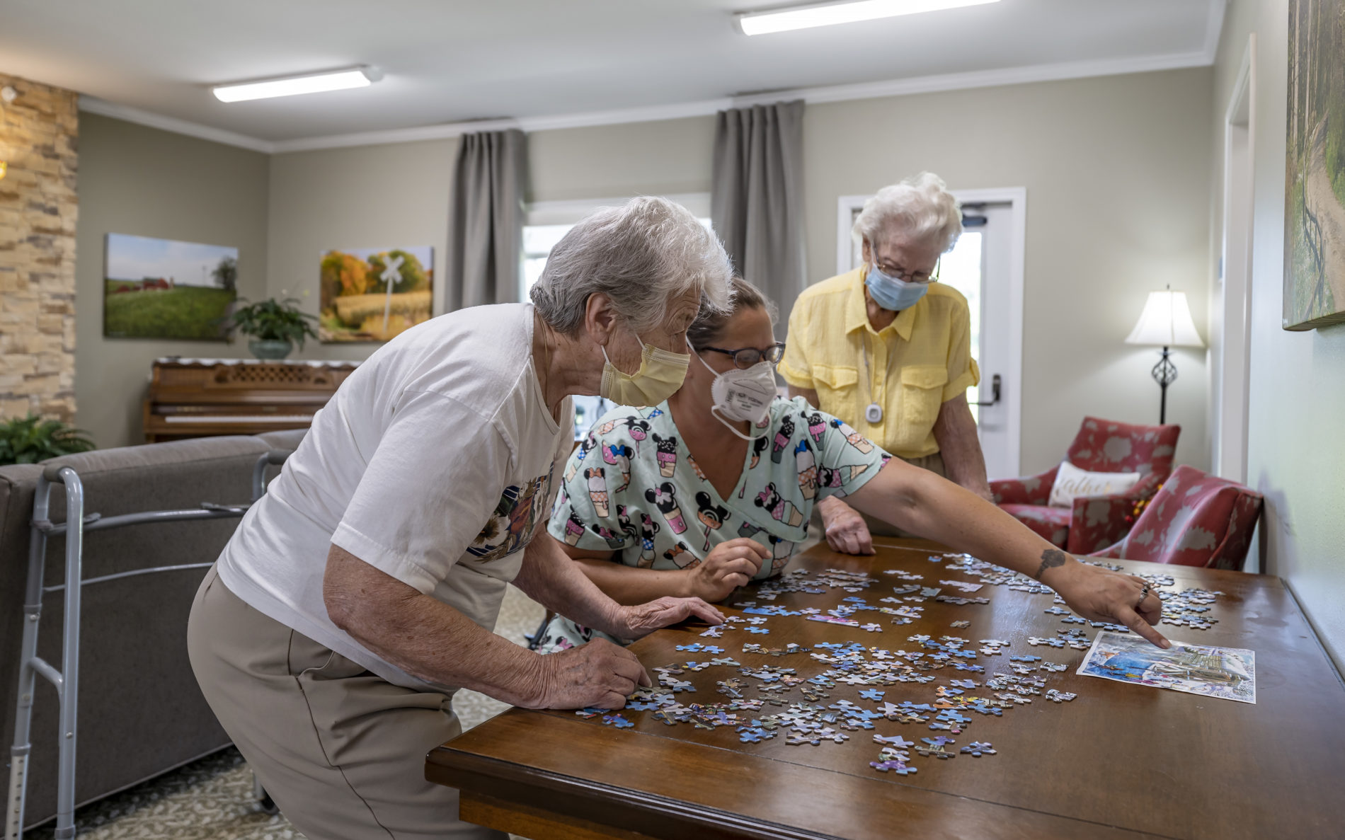 Seniors and staff member doing puzzle